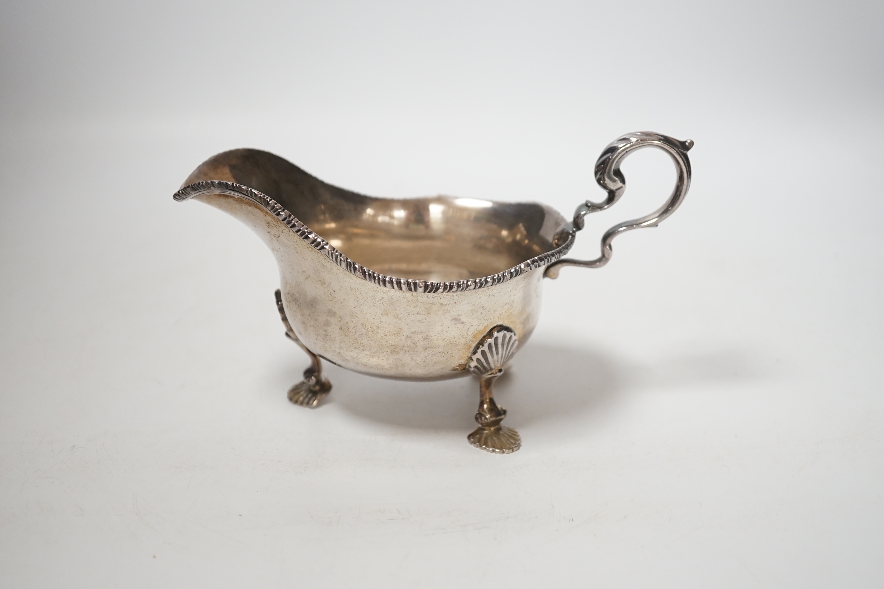 A George V silver sauceboat, on three shell feet, Thomas of New Bond Street, London, 1918, length 17cm, 8oz.